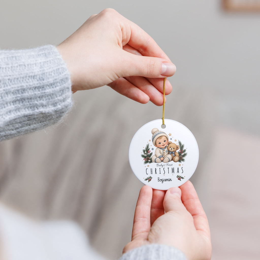 Hand holding the personalized Baby Boy First Christmas ornament by its gold string