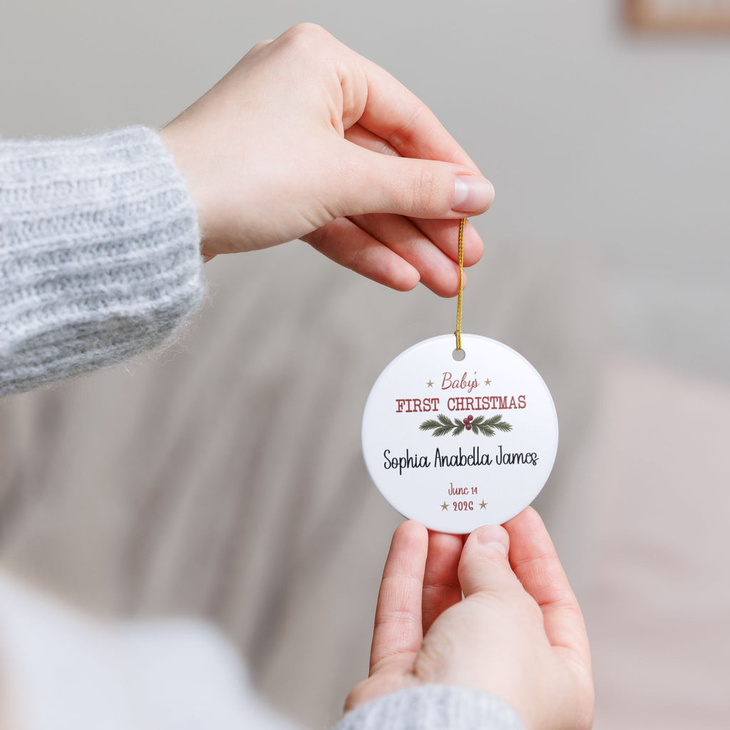 Hand holding the personalized Baby's First Christmas Keepsake ornament by its gold string