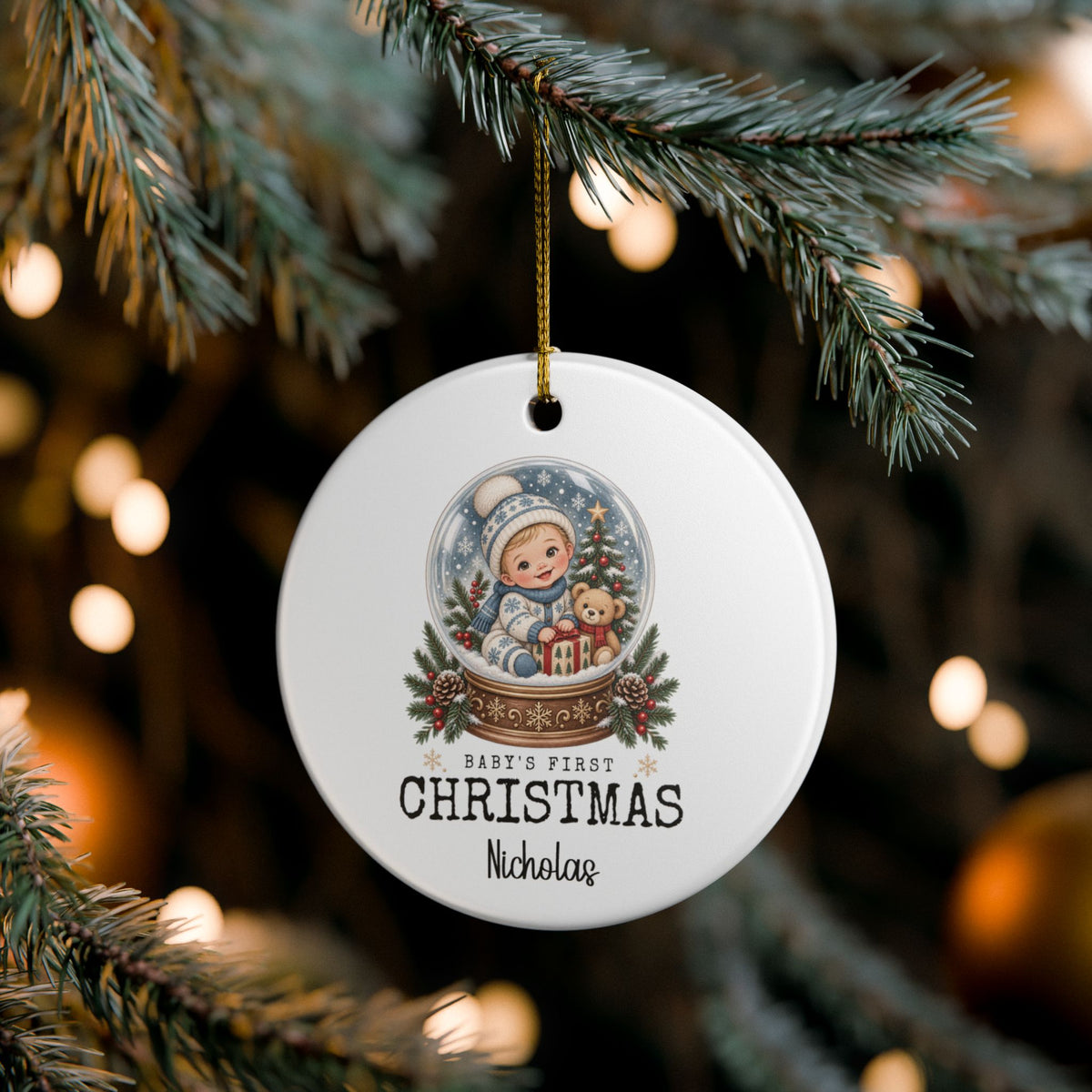 Custom baby's first Christmas snow globe ornament on pine branches with twinkling Christmas lights