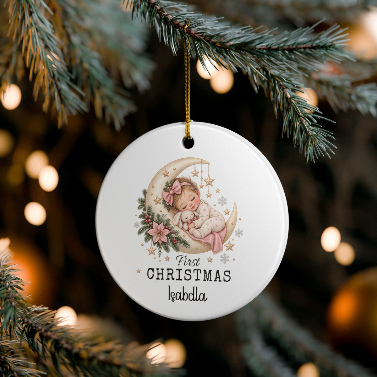 Baby Girl First Christmas Moon ornament hanging on a lit Christmas tree, lifestyle photo