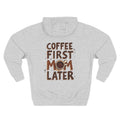 A heather grey long-sleeve hoodie shown from the back, featuring a graphic print that reads 'COFFEE FIRST MOM LATER' in brown lettering with a coffee cup illustration. Special gift for mom.