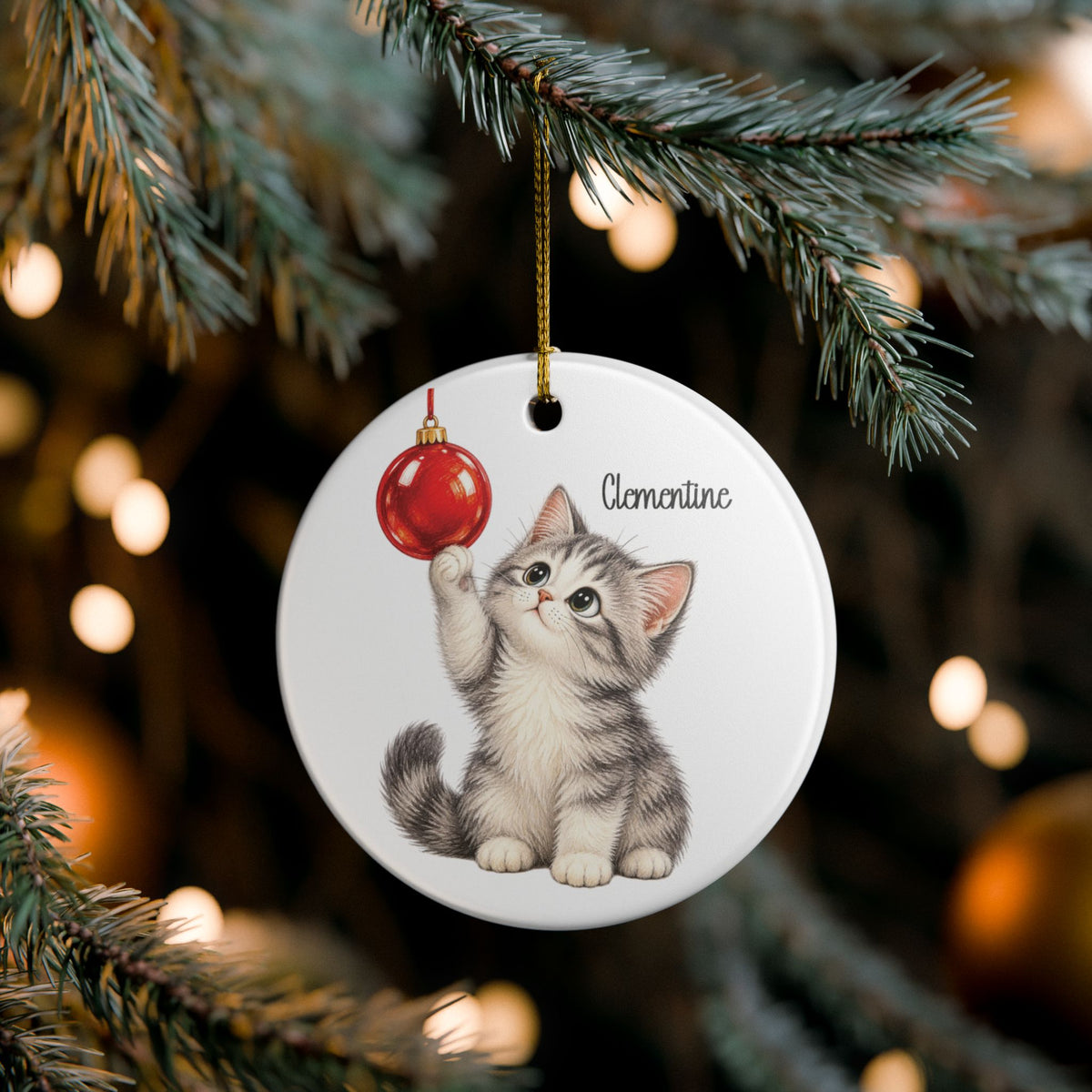 Christmas Kitten ornament hanging on a lit Christmas tree, lifestyle photo