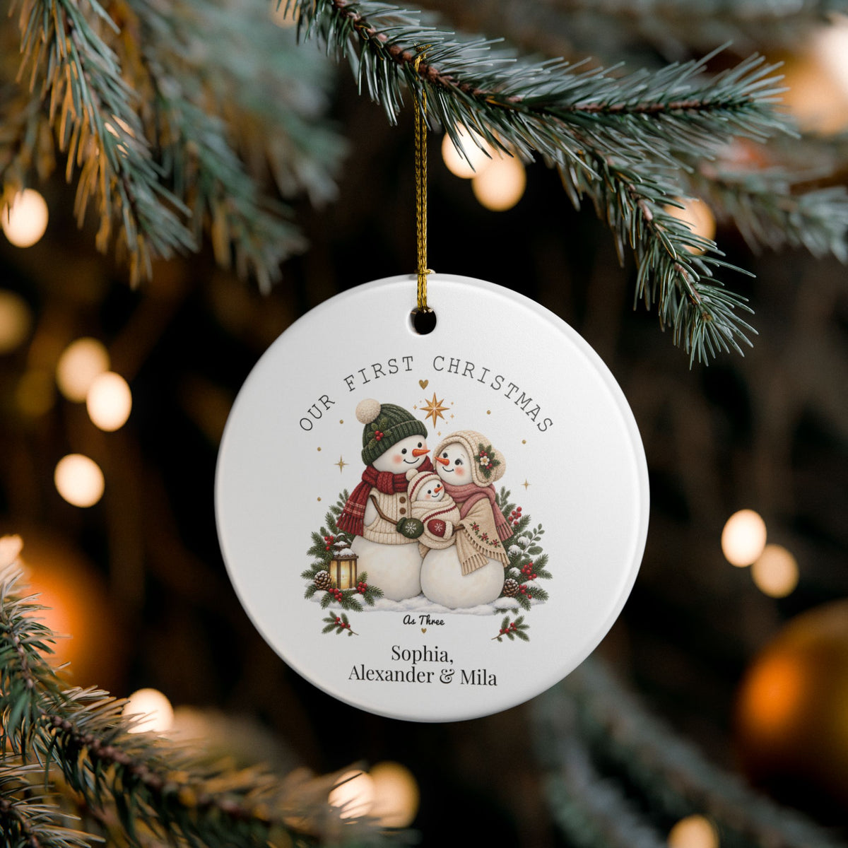 Our First Christmas as Three ornament hanging on a lit Christmas tree, lifestyle photo