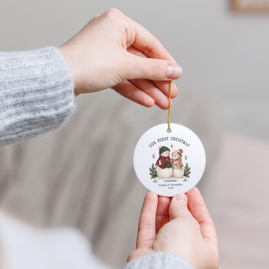 Hand holding the personalized Our First Christmas Together ornament by its gold string