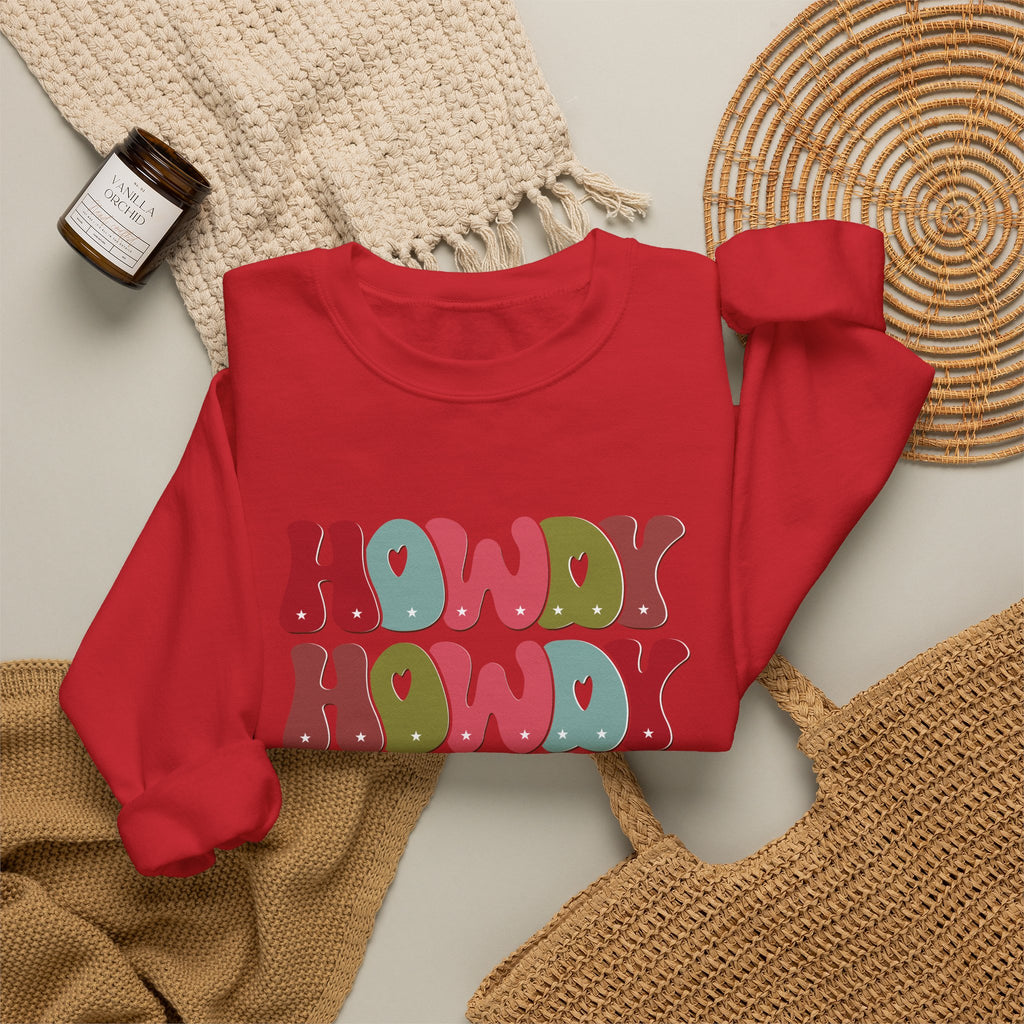 Red personalized Howdy Howdy Christmas sweatshirt, flat lay with cozy knit blanket