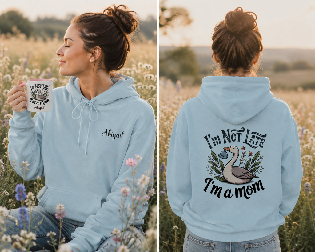 A woman wearing a light blue hoodie is shown in a field, with a front view on the left and a back view on the right. The front has the name 'Abigail' embroidered on the chest, and the back features a graphic of a goose with the text 'I'm Not Late I'm a mom'.