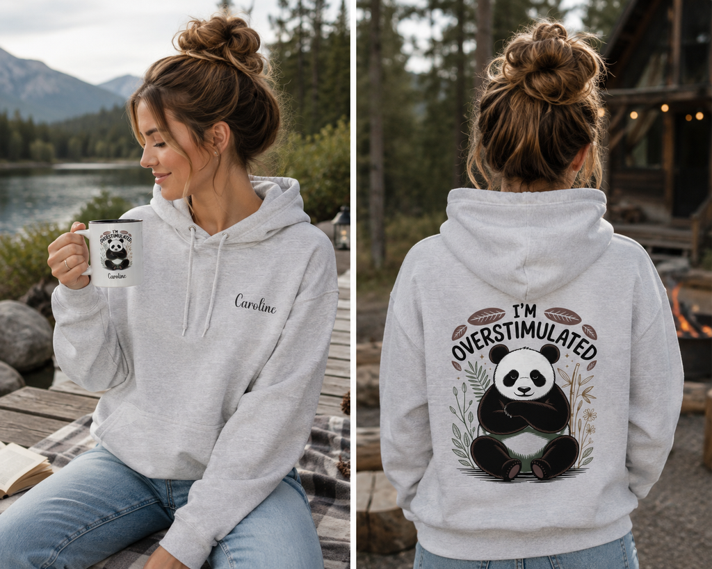 A woman wearing a light heather gray hoodie is shown in a split view, for her or mom, holding a mug in a lakeside setting and standing outdoors to show the back graphic. The hoodie has a panda illustration with the text 'I'M OVERSTIMULATED' and 'Caroline' printed on the chest.