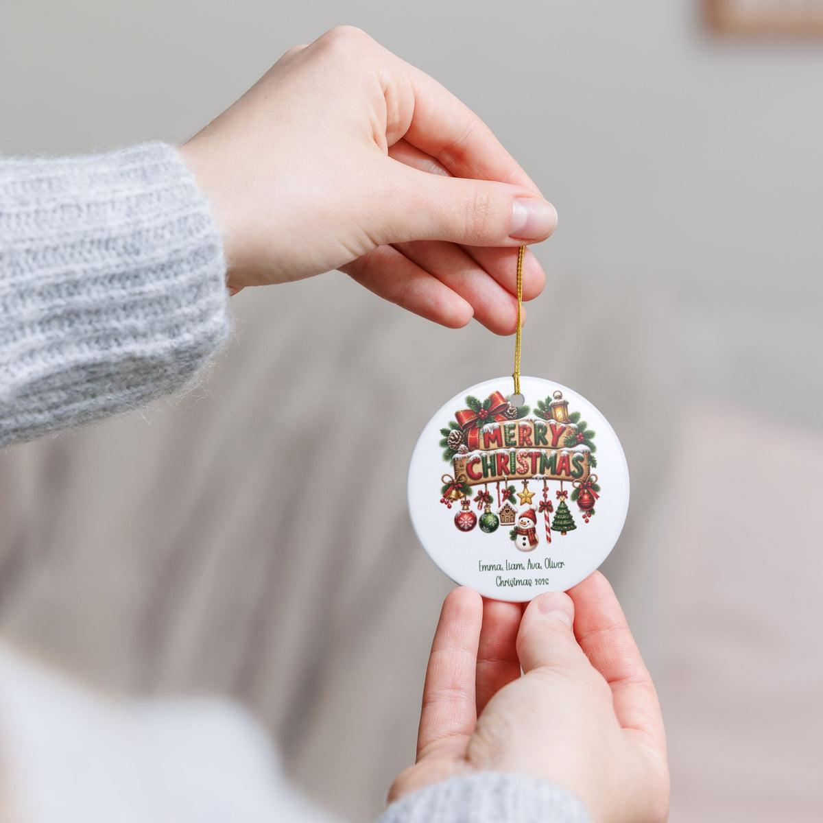 Hand holding the personalized Merry Christmas Family ornament by its gold string