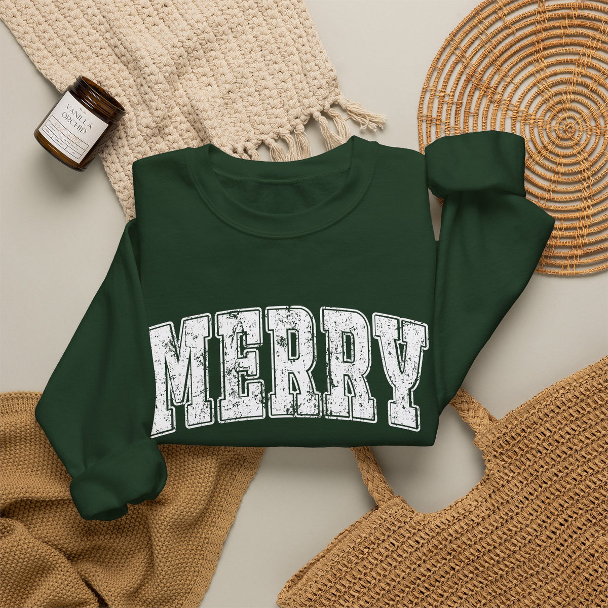 Forest Green personalized Merry Varsity sweatshirt, flat lay with cozy knit blanket