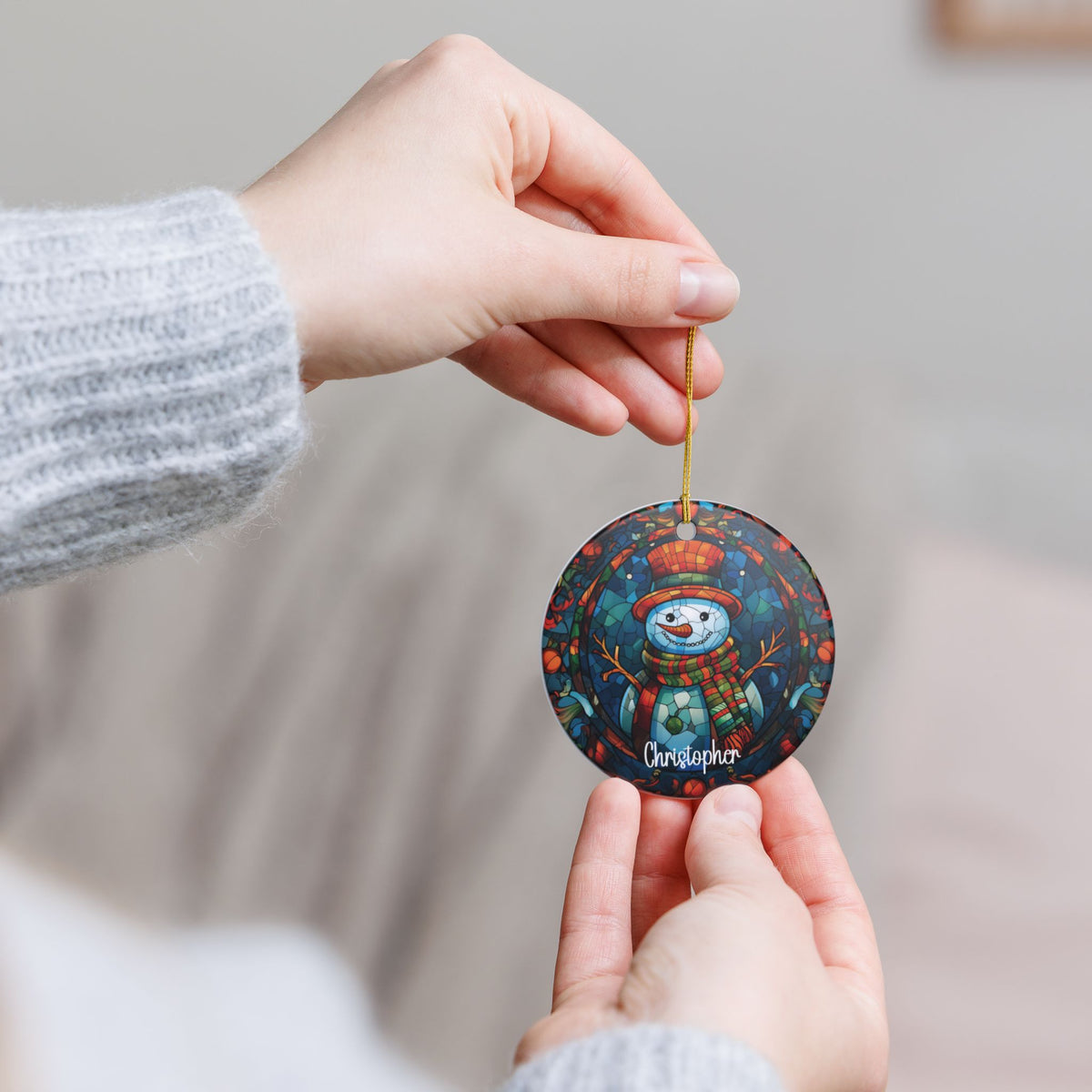 Hand holding the personalized Colorful Mosaic Snowman ornament by its gold string