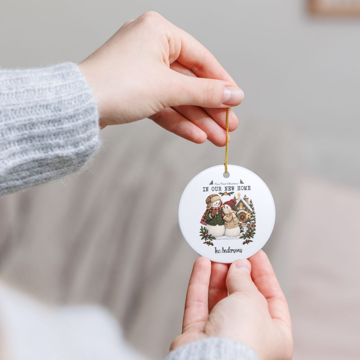 Hands holding the personalized First Christmas in Our New Home ornament to show its size