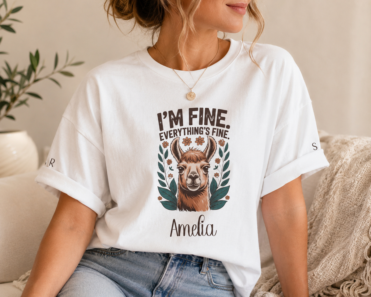 A woman wearing a white graphic t-shirt with a llama design and the text 'I'M FINE. EVERYTHING'S FINE.' and 'Amelia'.