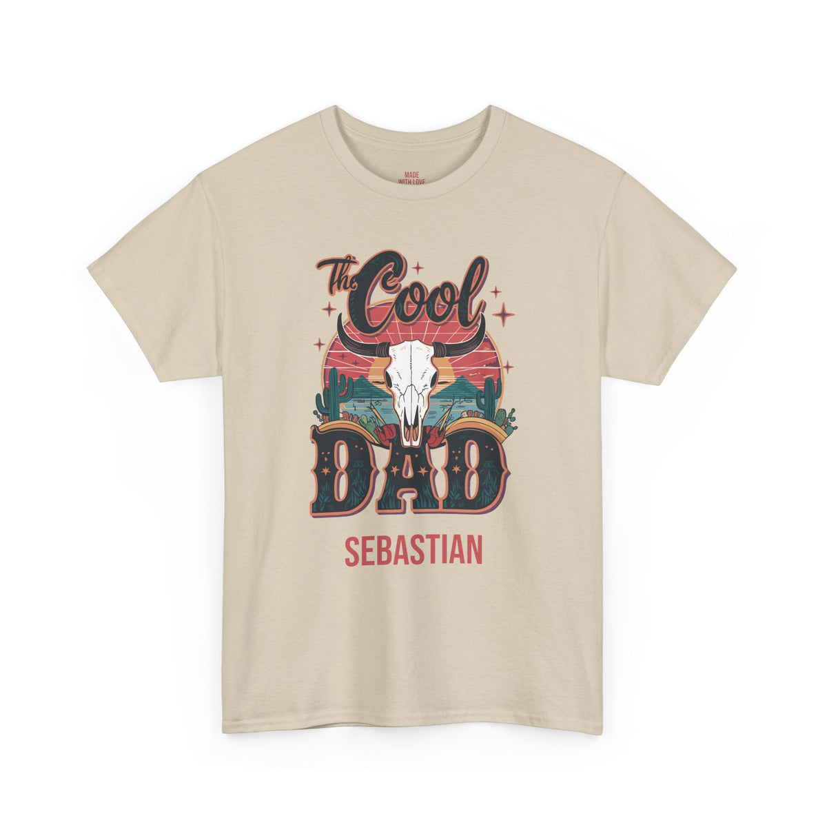 A beige short-sleeve crewneck t-shirt with a graphic print on the front. The graphic features the text 'The Cool DAD' in stylized lettering, a white skull, and 'SEBASTIAN' printed below in red.