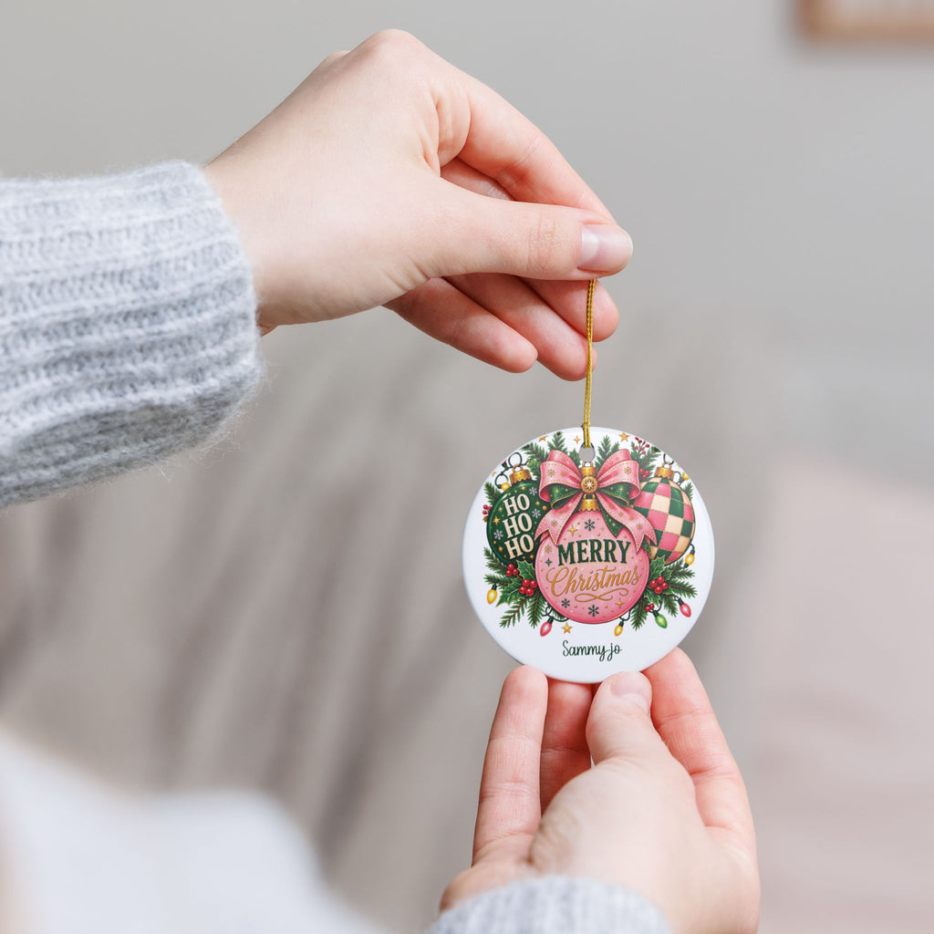 Hand holding the personalized Pink Christmas Bow ornament by its gold string