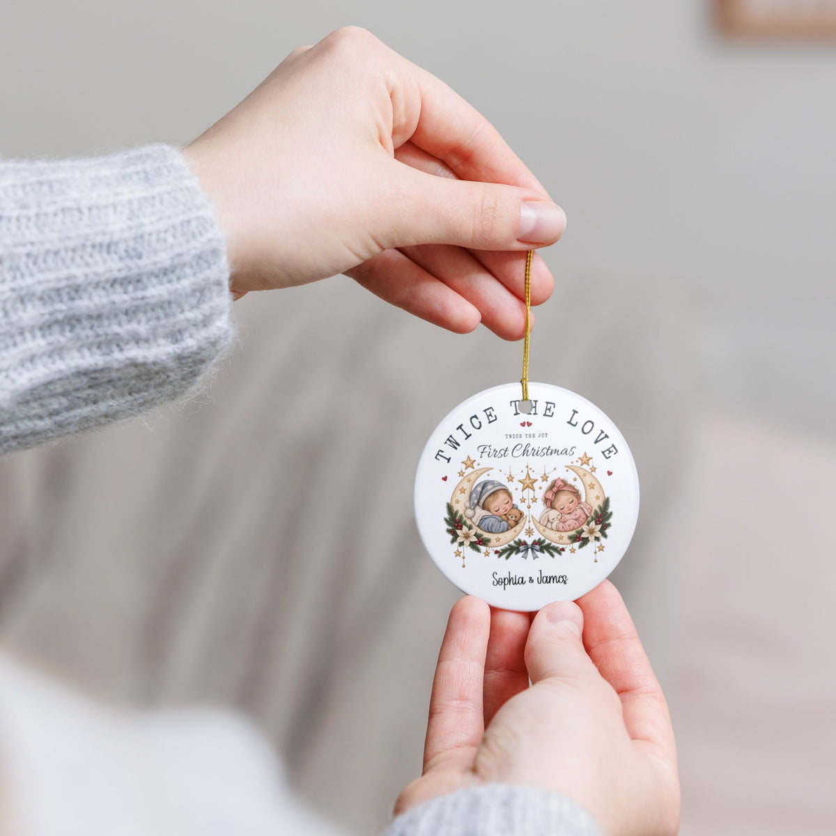 Hand holding the personalized Twice the Love First Christmas ornament by its gold string