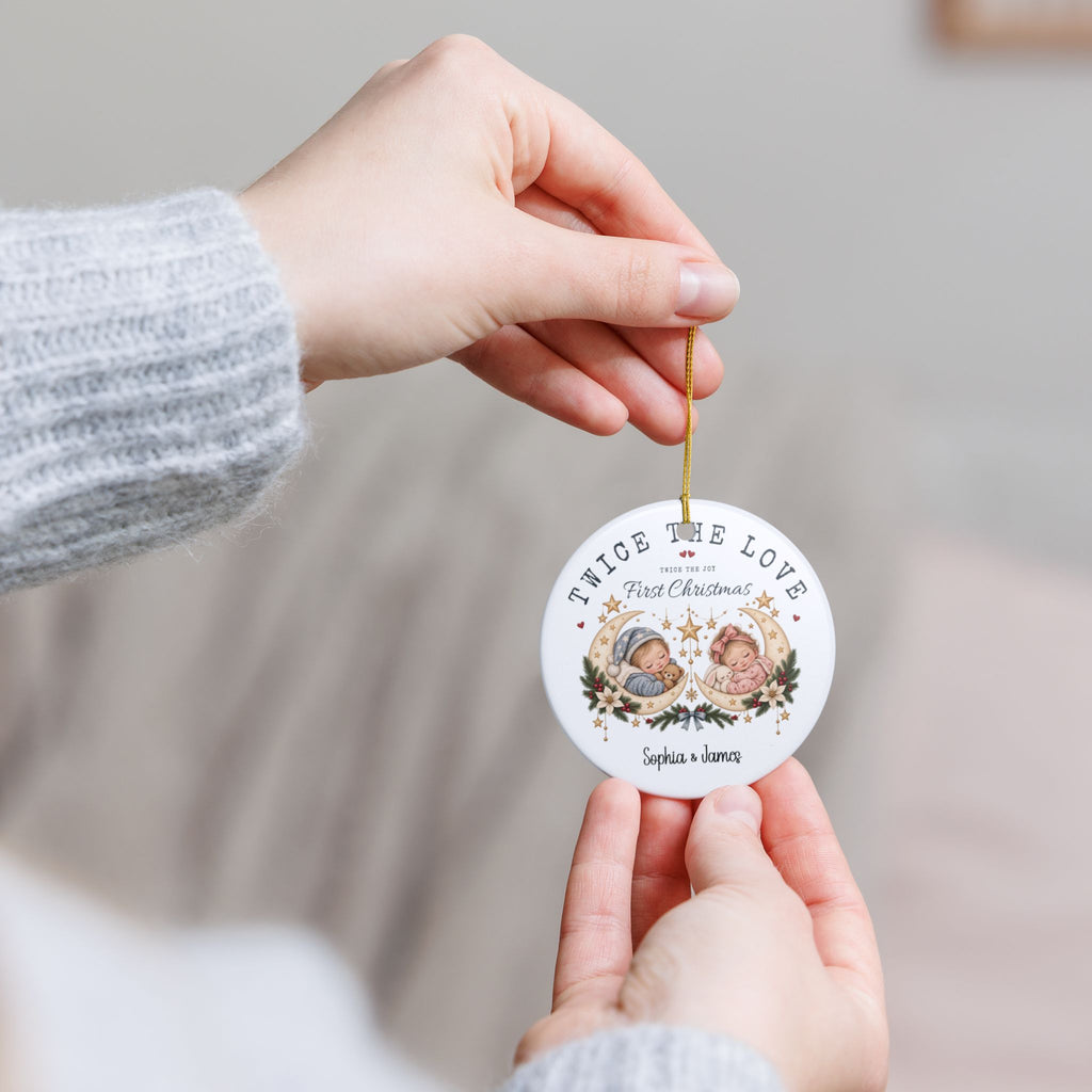 Hands holding the personalized Twice the Love First Christmas ornament to show its size