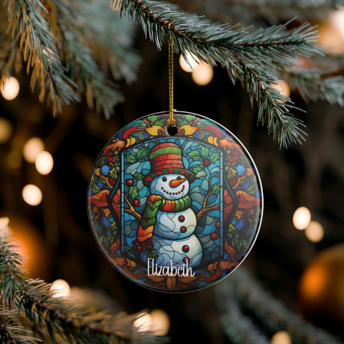 Woodland Stained Glass Snowman ornament hanging on a lit Christmas tree, lifestyle photo